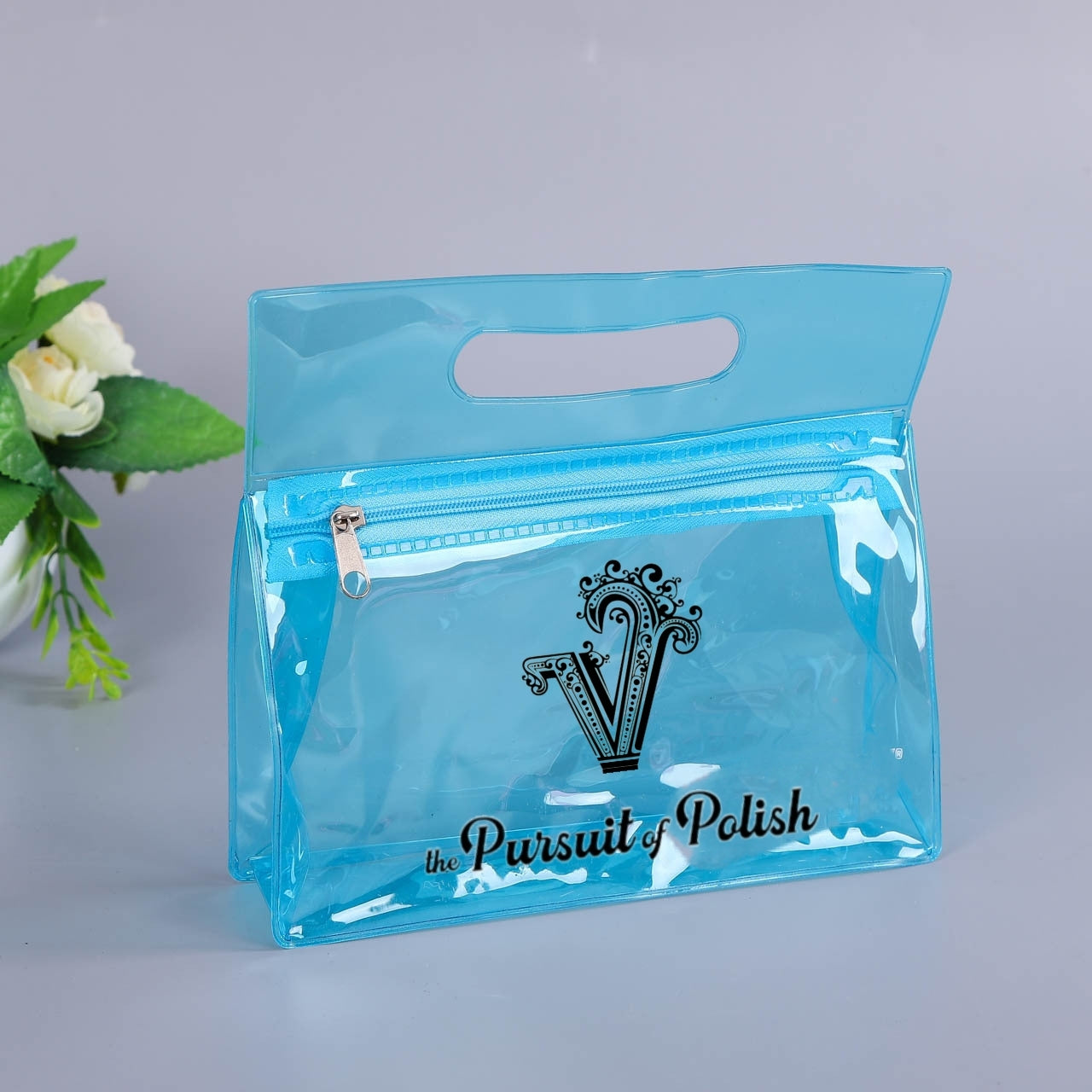Clear blue pouch with 'the Pursuit of Polish' logo on a light gray background