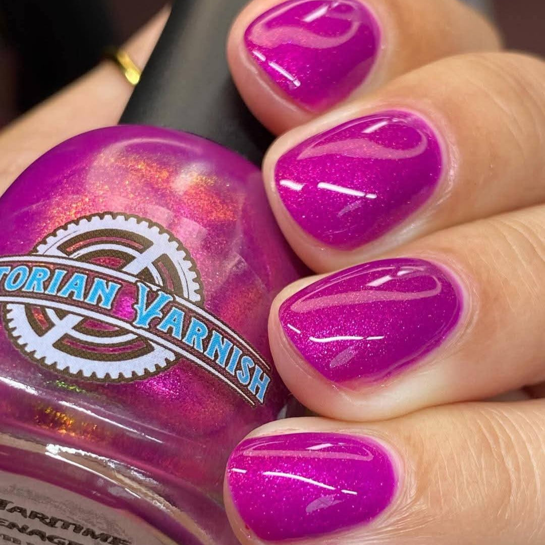 Hand with purple nail polish holding a jar of Victorian Varnish nail polish.