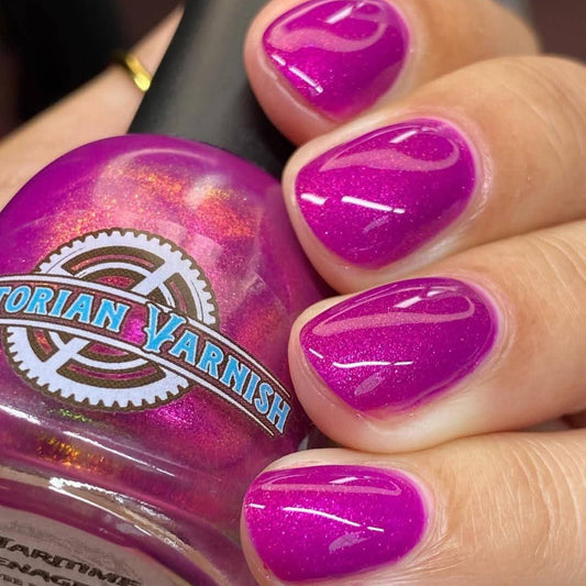 Hand with purple nail polish holding a jar of Victorian Varnish nail polish.