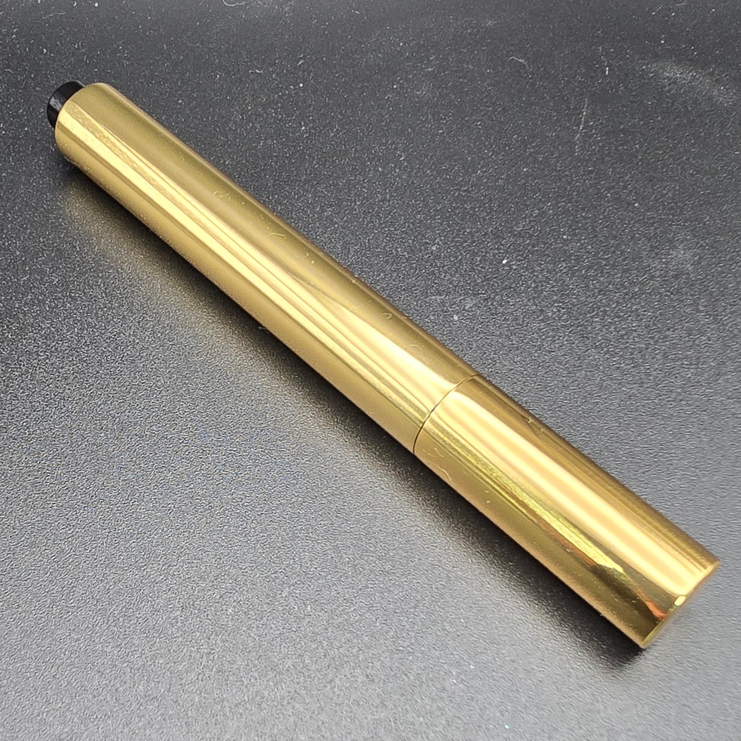 Gold pen on a gray background