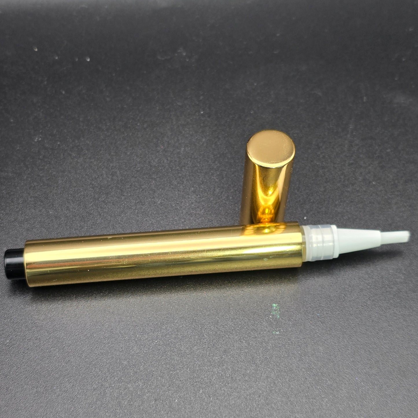 Gold pen with a white cap on a gray background