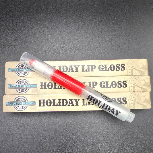 Red lip gloss with 'Holiday' text on a gray background